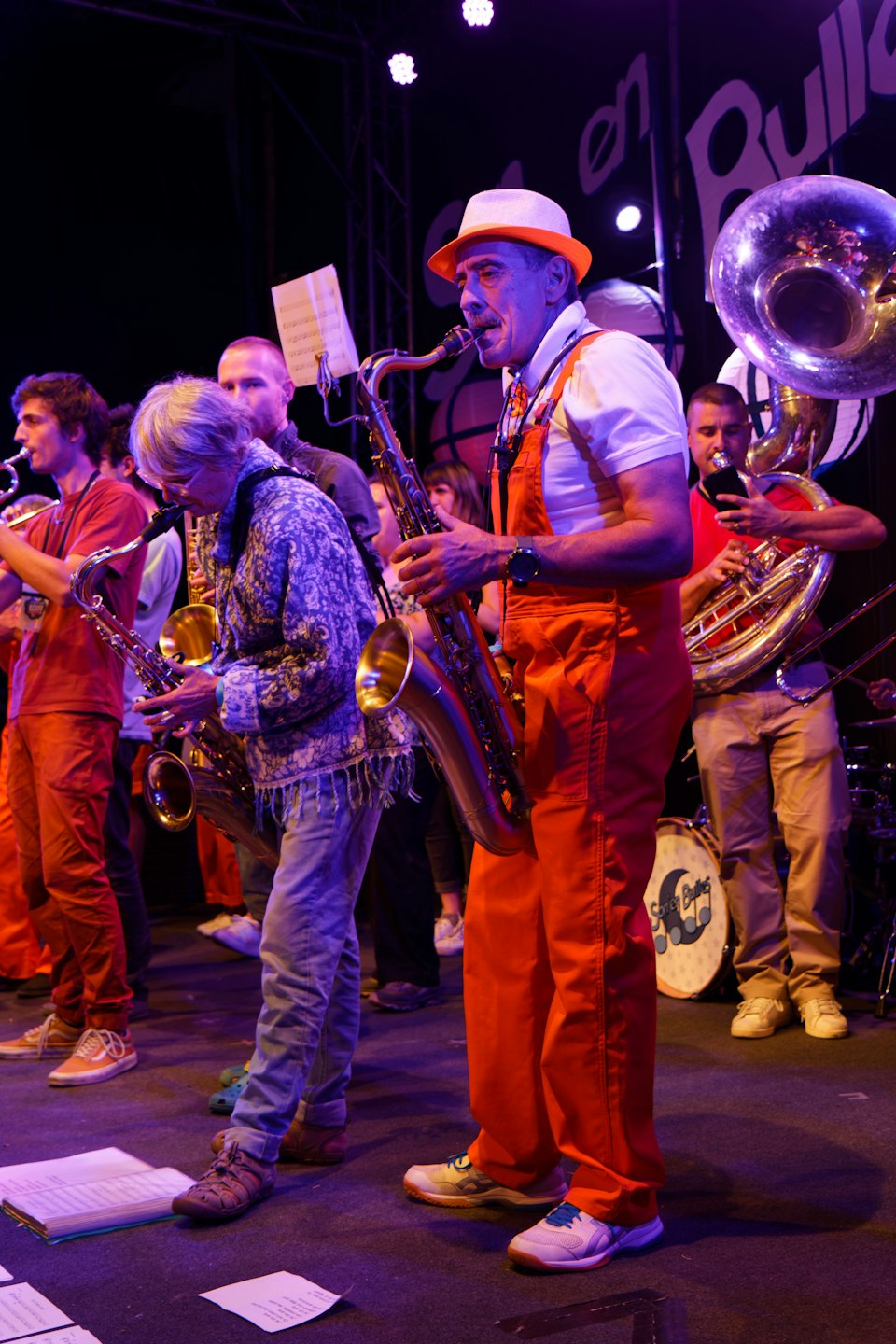 Zwei Saxophonisten treten mit einer Blaskapelle auf der Bühne auf.
